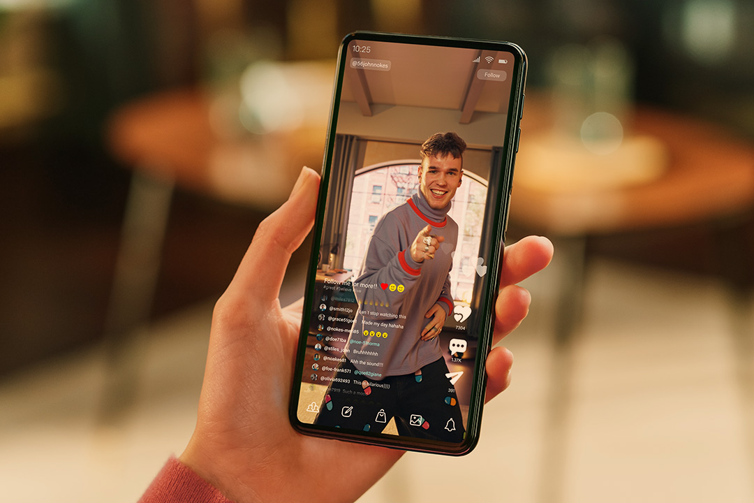person haelt handy in der hand und sieht sich einen livestream an