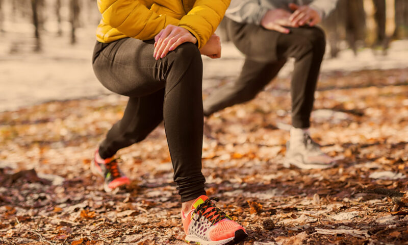 zwei personen dehnen sich vor dem sport