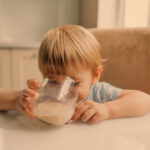 kind trinkt milch aus glas