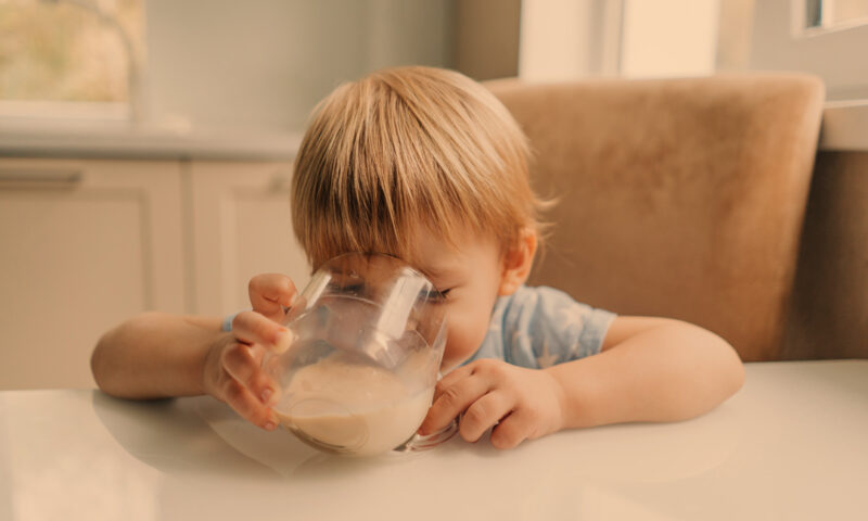 kind trinkt milch aus glas